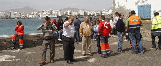 Una veintena de familiares de los pescadores desaparecidos esperan la llegada de los buzos en el muelle