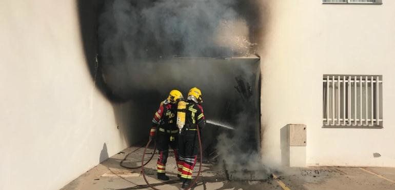 Un incendio en un garaje calcina varios muebles y afecta a una vivienda al romperse los cristales por las llamas