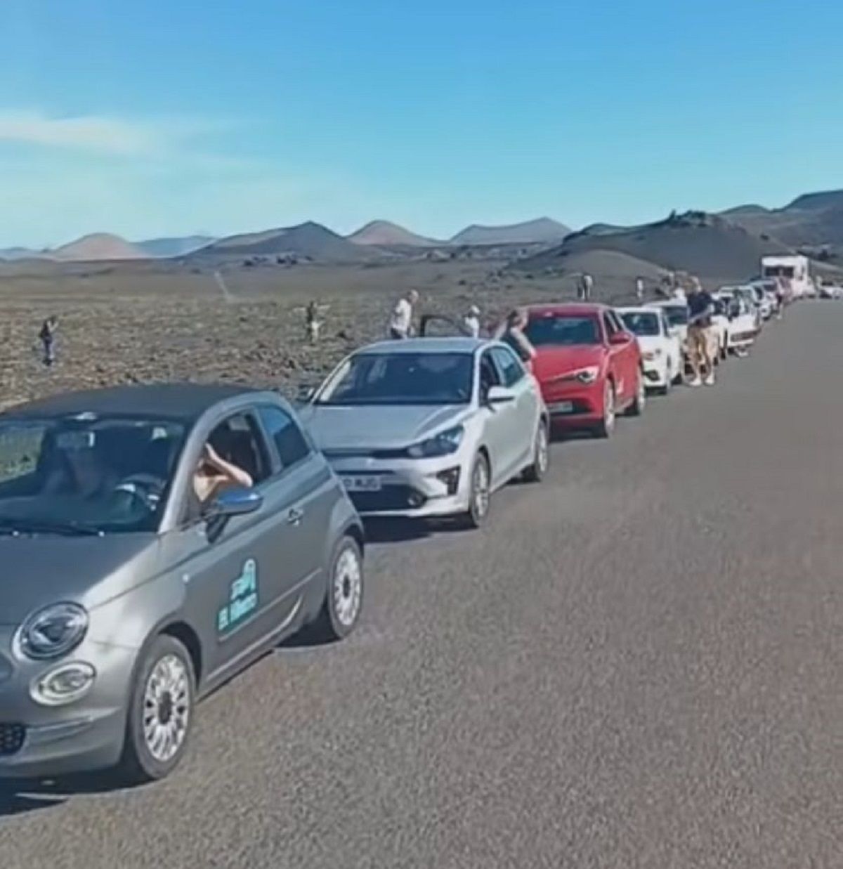 Turistas caminando sobre las montañas de lava del Parque Nacional de Timanfaya