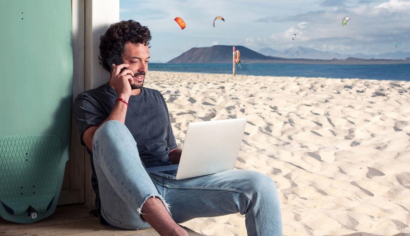 Un joven teletrabajando con vistas a isla de Lobos y Lanzarote. Imagen: Turismo de Canarias