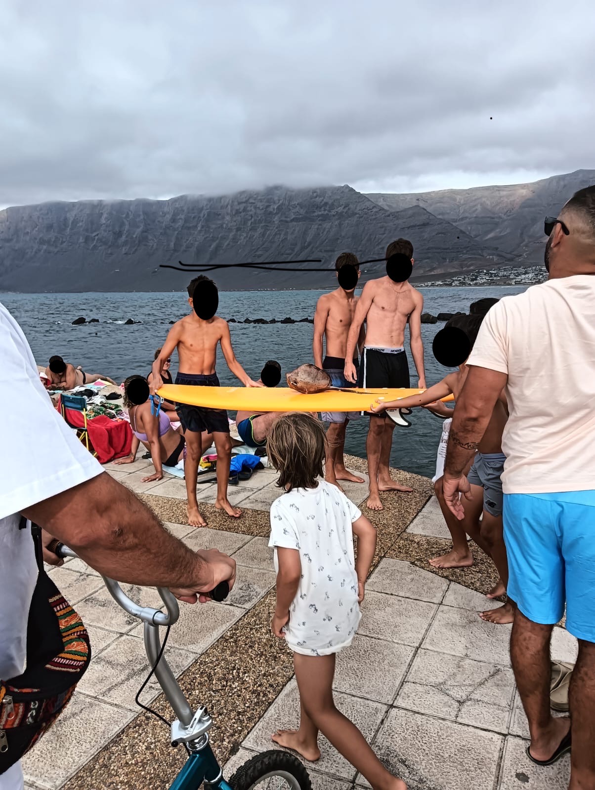 Un grupo de jóvenes rescata un ejemplar de chucho negro en el muelle de Caleta de Famara