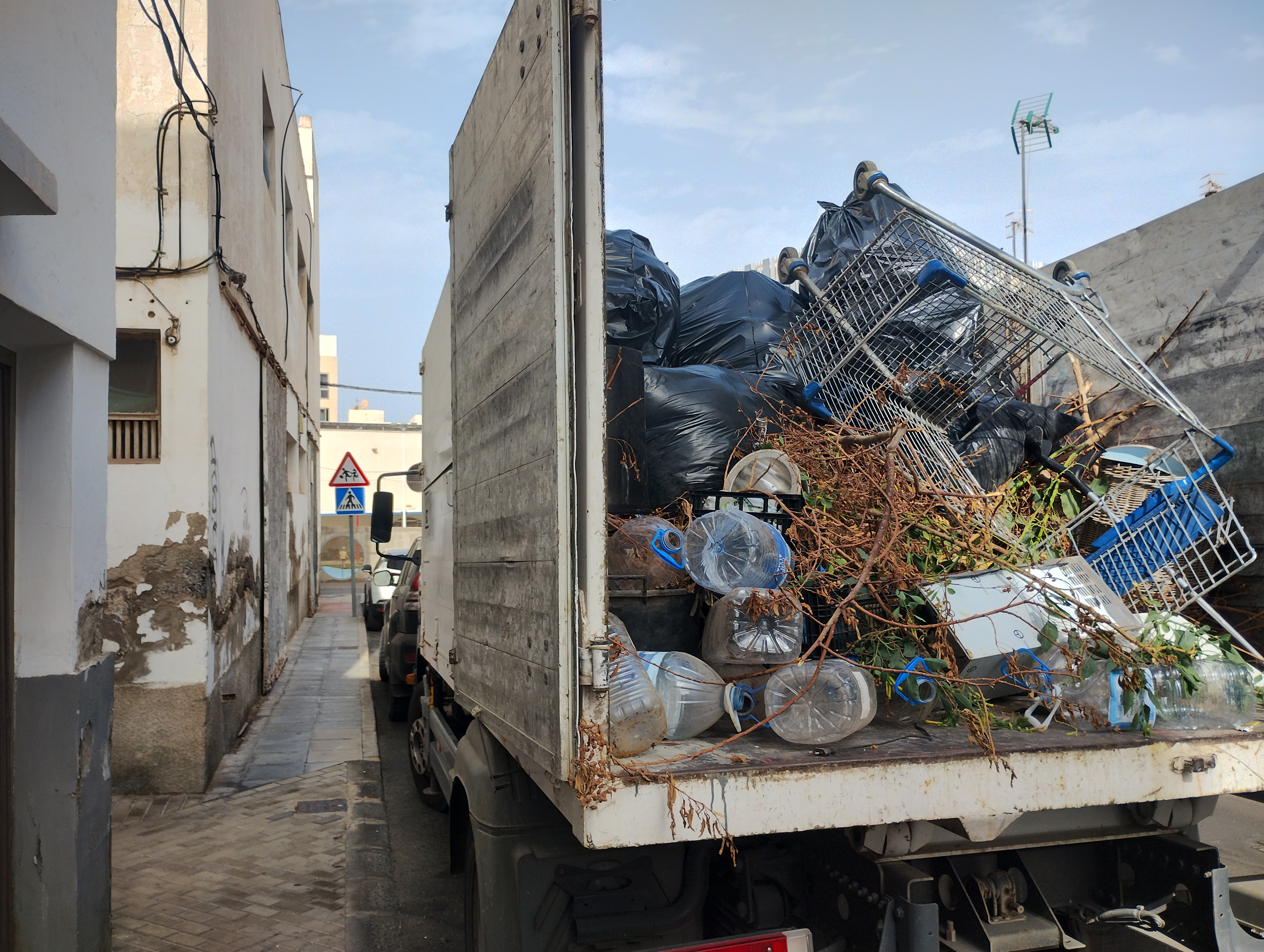 Un camión con la  basura que se encontraba en el interior de esta casa okupada. La retirada de los residuos ha sido por la propiedad del inmueble, a requerimiento del Ayuntamiento 