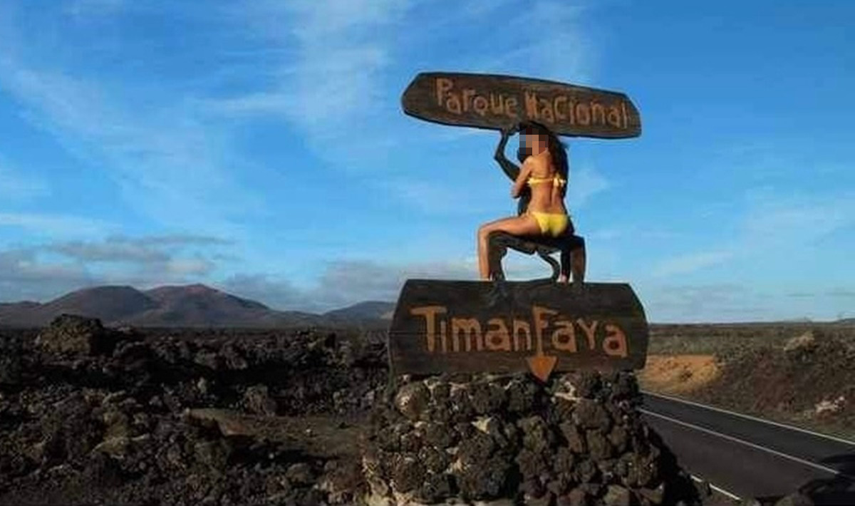 Una mujer en bikini abrazada al diablo de Timanfaya