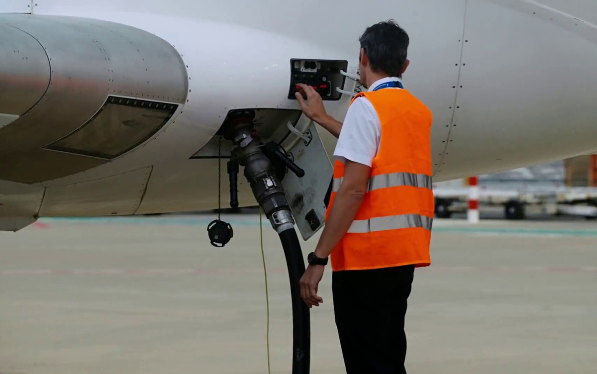 Un trabajador suministra SAF a un avión. Combustibles y sostenibilidad. Aeropuerto.