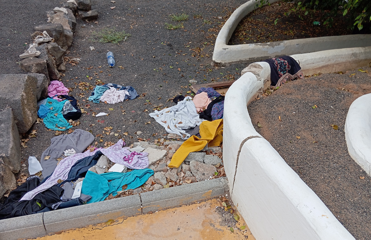 Prendas de ropa en el suelo en los jardines del centro comercial de Costa Teguise