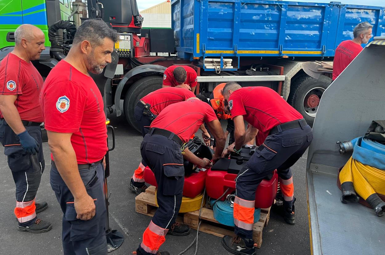 Bomberos colaborando en la carga del material