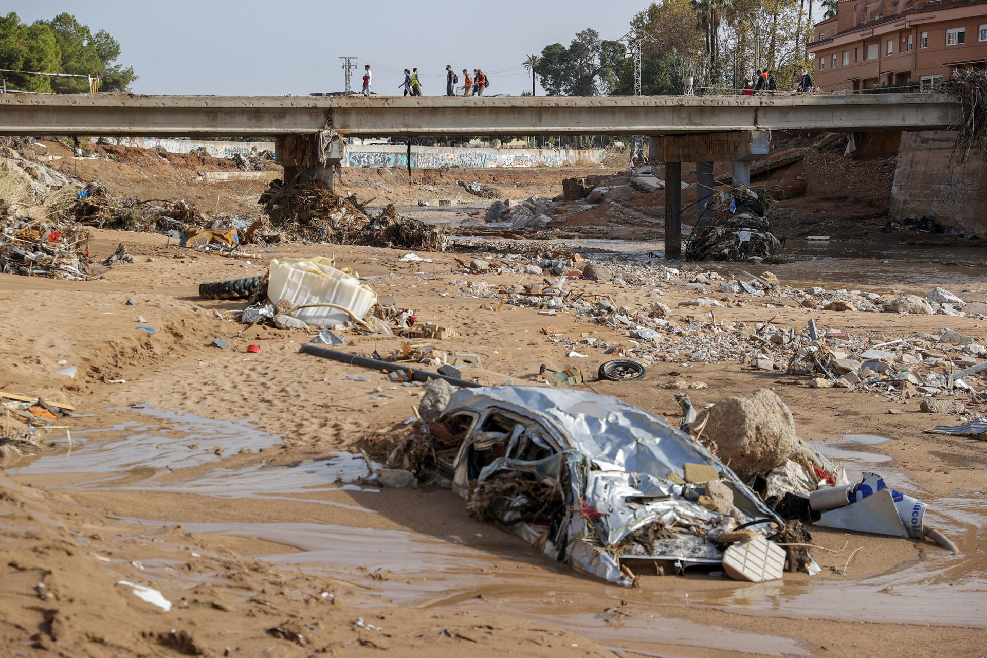 Restos de vehículos arrastrados por la corriente en el barranco del Poyo en Paiporta, Valencia, este lunes, tras el paso de la DANA. EFE/ Manuel Bruque