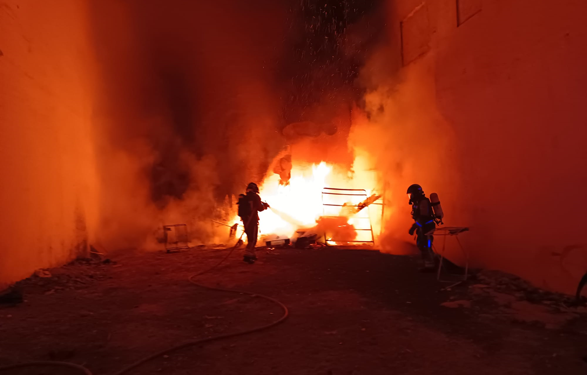 Bomberos sofocando el incendio en el solar