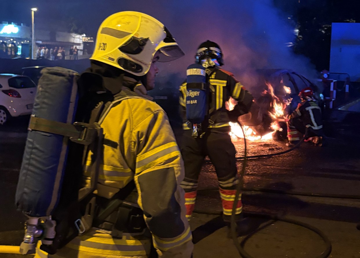 Bonbemros voluntarios apagando el incendio de un coche